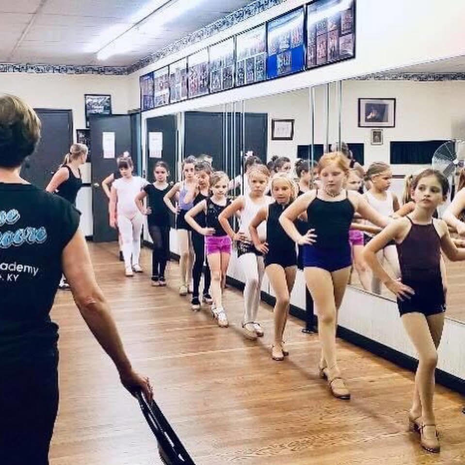 Interior of the dance studio with wood floors, mirrors, and warm lighting